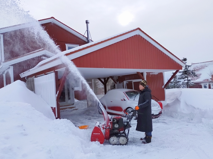 家の前を除雪する人